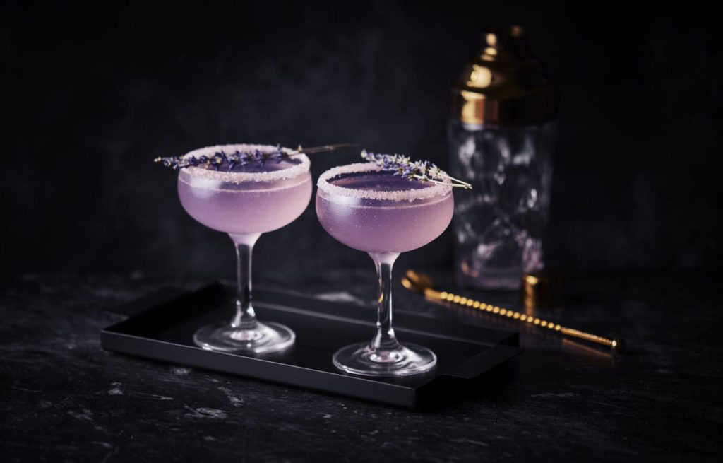 Two purple cocktails in martini glasses