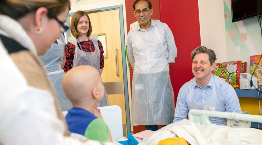 Staff in hospital laughing with young patient